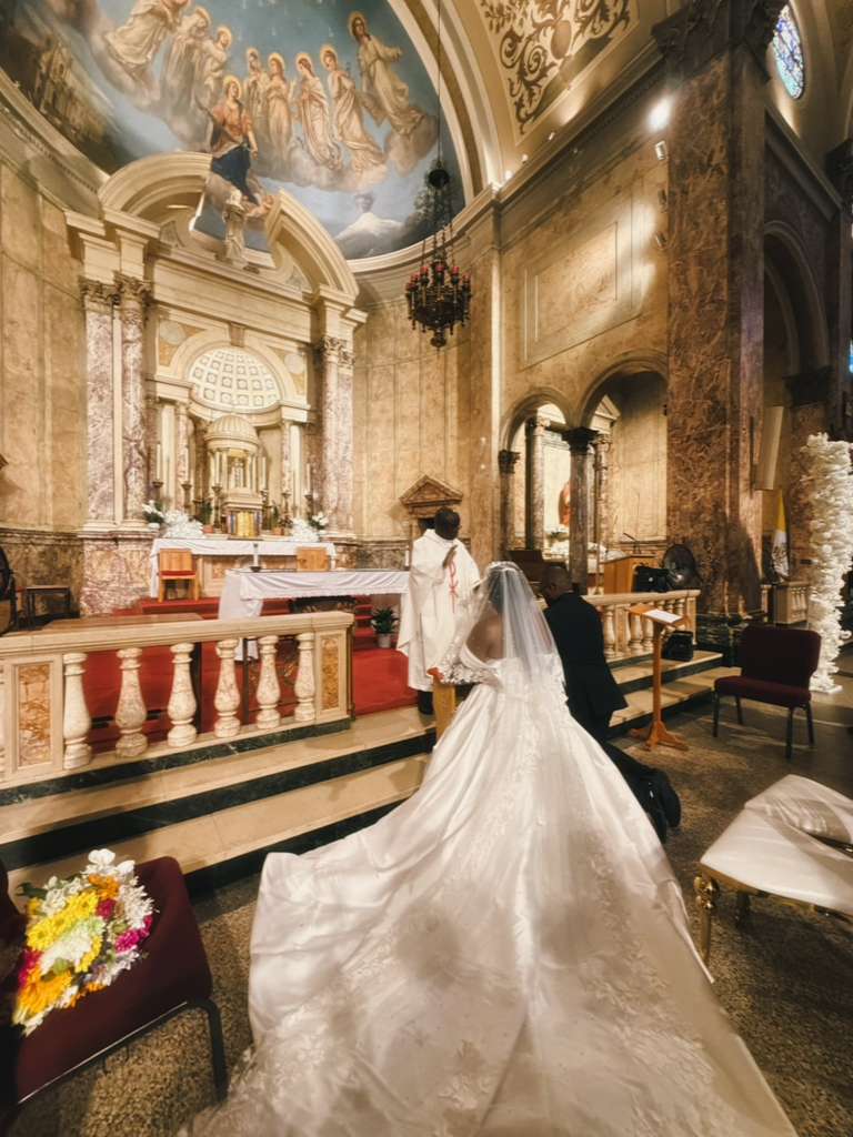A bride and groom at the altar of an ornate church during their ceremony